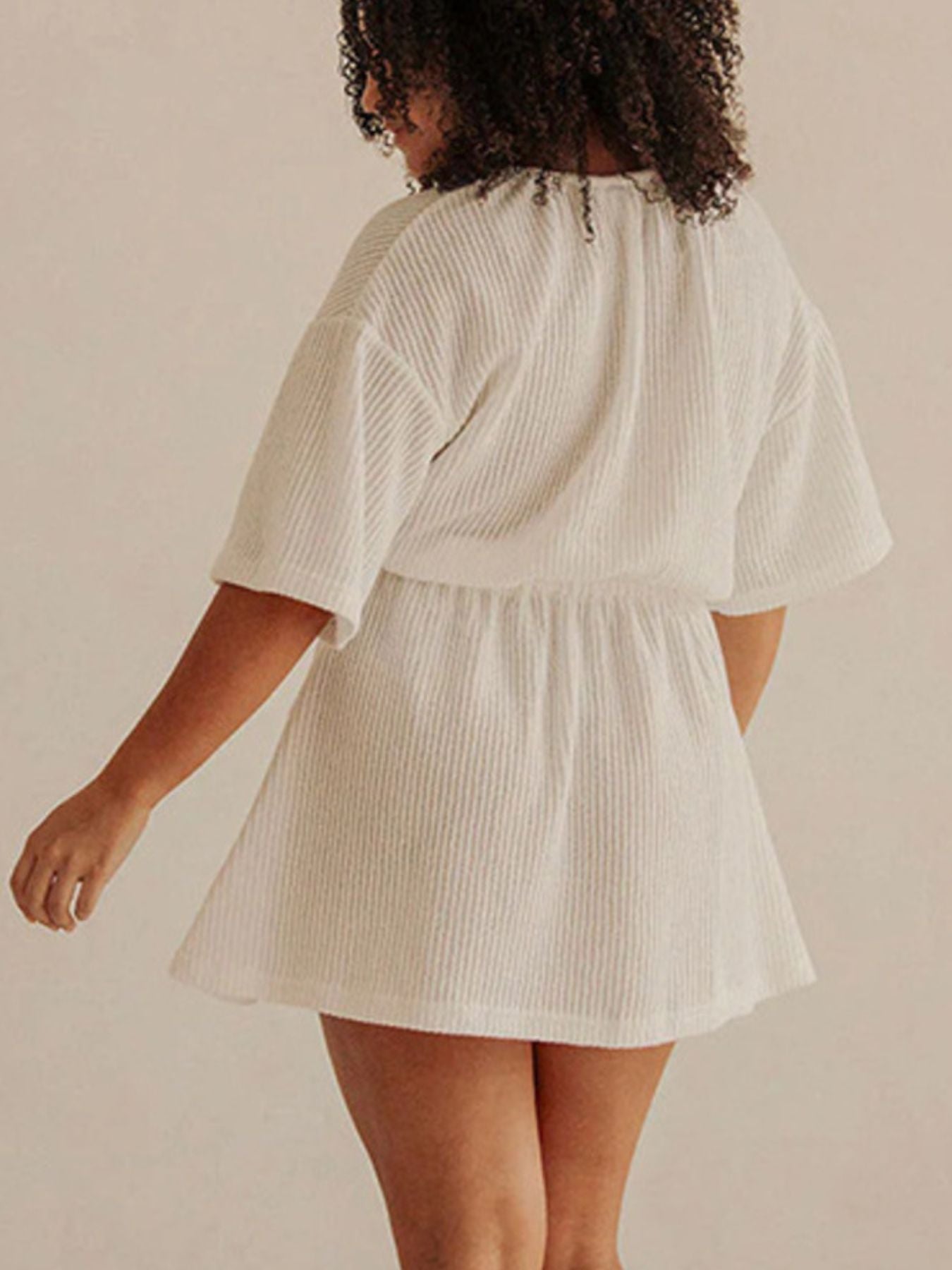 Textured white half sleeve cover-up dress with cinched waist and flared skirt.