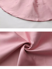 Pink midi dress fabric detail showing smooth texture and hemline.
