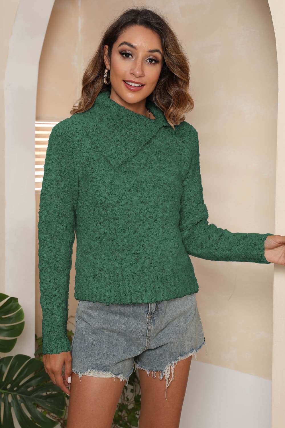 Dark green textured knit sweater with an asymmetric collar and long sleeves.