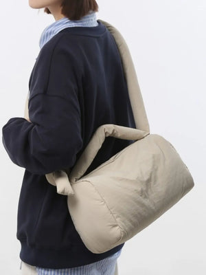 Padded knot shoulder bag in beige with a slouchy, soft silhouette.