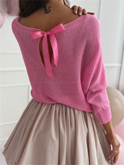 Fuchsia pink knit sweater with batwing sleeves and a bow-tie back cutout.