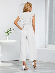 White pleated ruffle wrap jumpsuit with belt and wide legs.