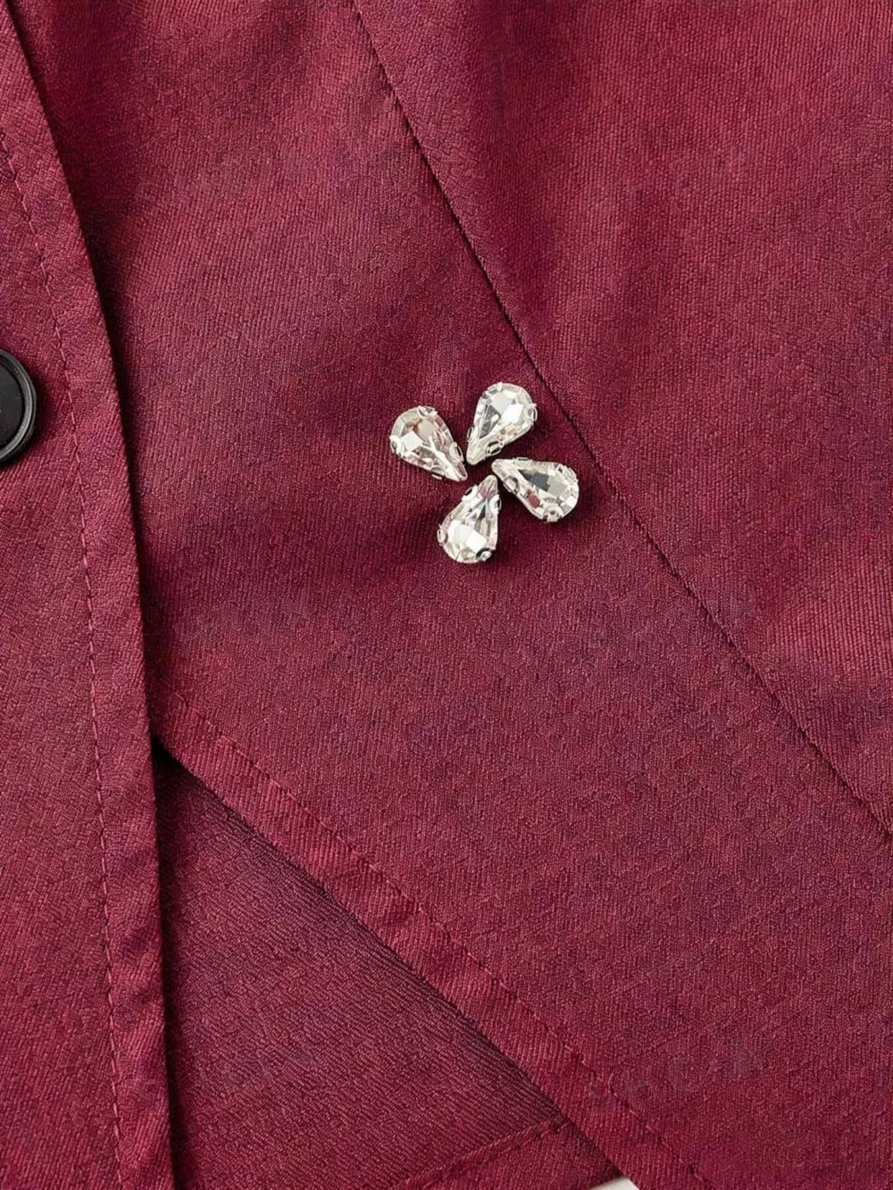 Burgundy vest with crystal flower applique and button front detail.
