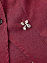Burgundy vest with crystal flower applique and button front detail.