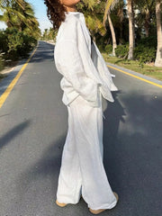 Relaxed fit white linen two-piece set with wide-leg pants and a button-up shirt.
