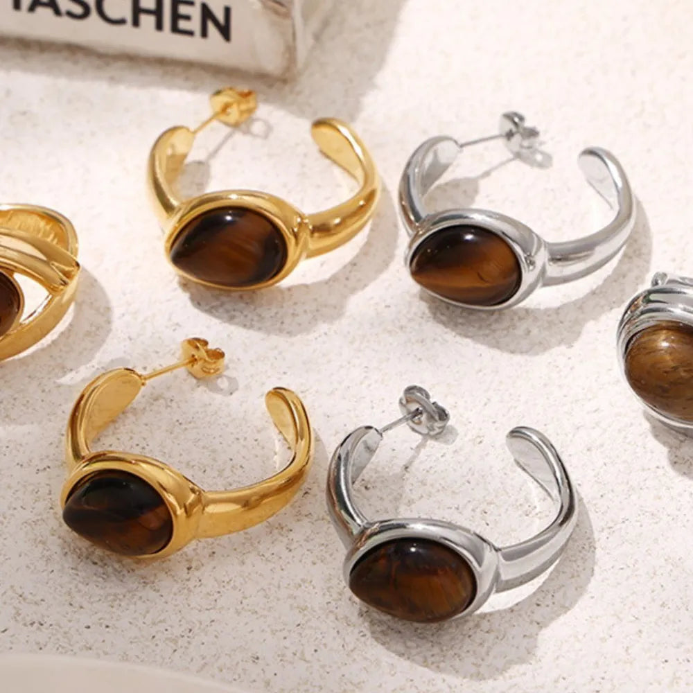 Gold and silver sculptural hoop earrings with tiger's eye stone detail