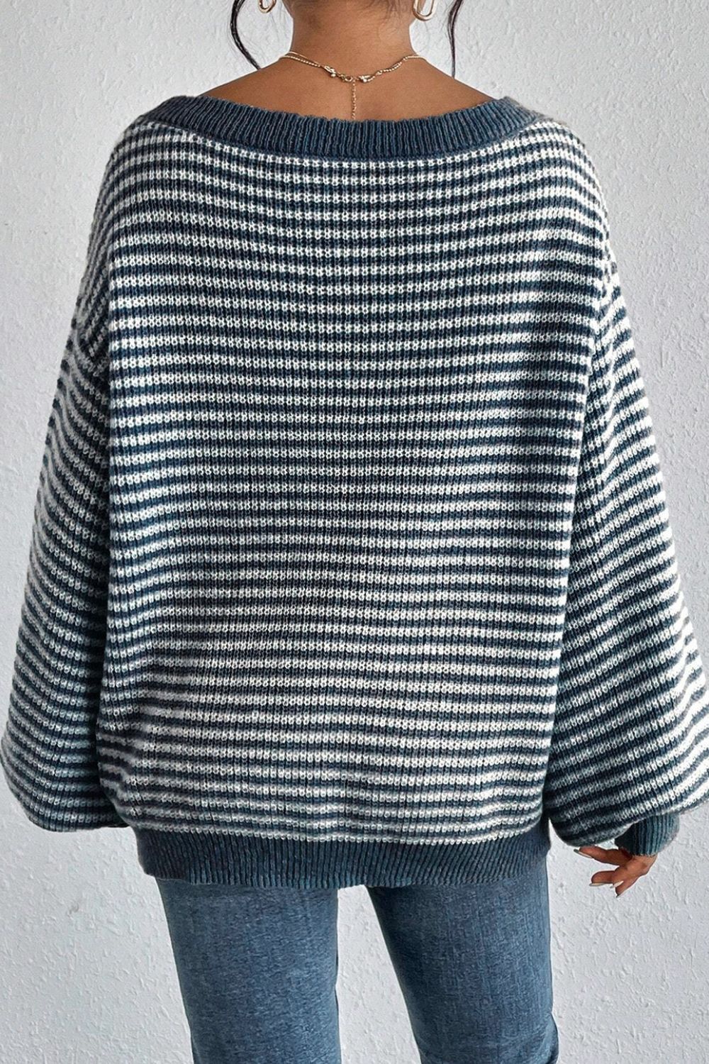 Blue striped off-shoulder knit pullover sweater with wide sleeves.