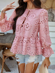 Dusty pink eyelet embroidered peplum blouse with tie neckline and ruffled cuffs.