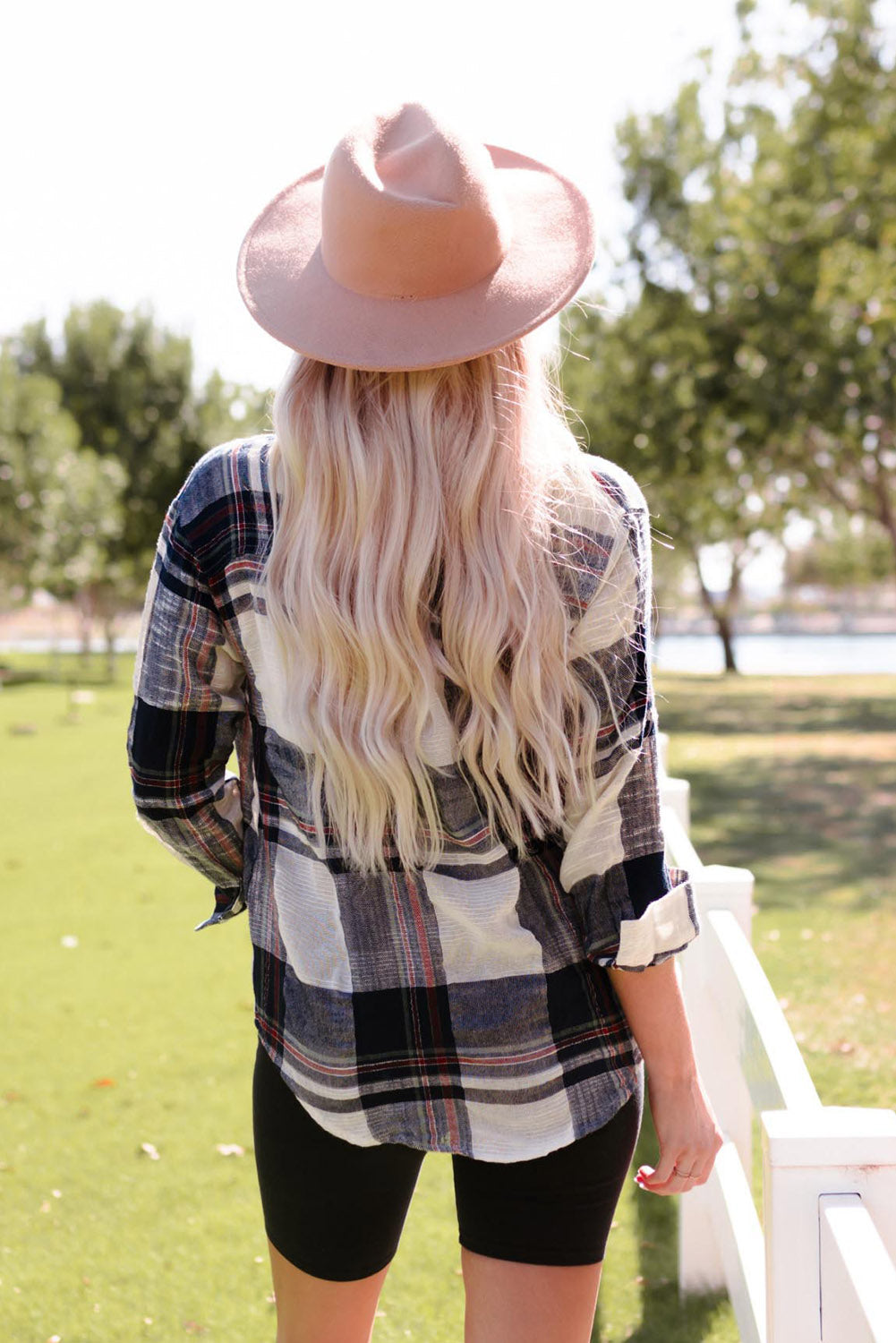 Linen plaid button-down overshirt with rolled sleeves, worn by a woman with blonde hair and a hat.