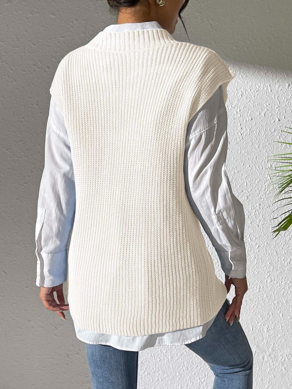 Ivory ribbed knit sleeveless vest over a light blue collared shirt.