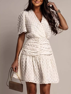 Off-white textured V-neck ruched mini dress with flutter sleeves.