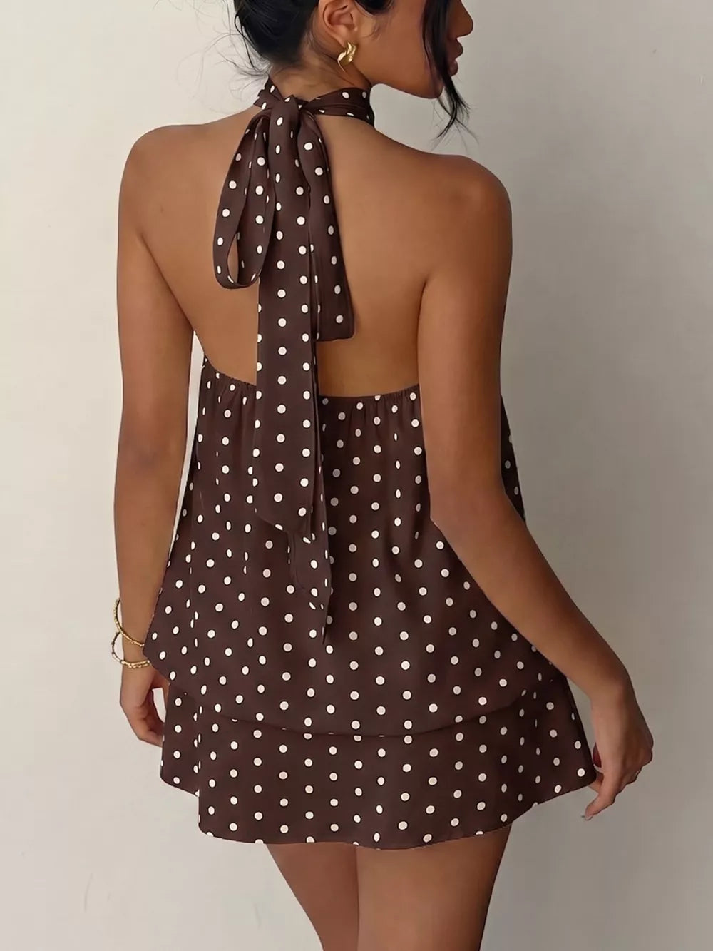 Coffee brown polka dot halter mini dress with a tie-back detail.