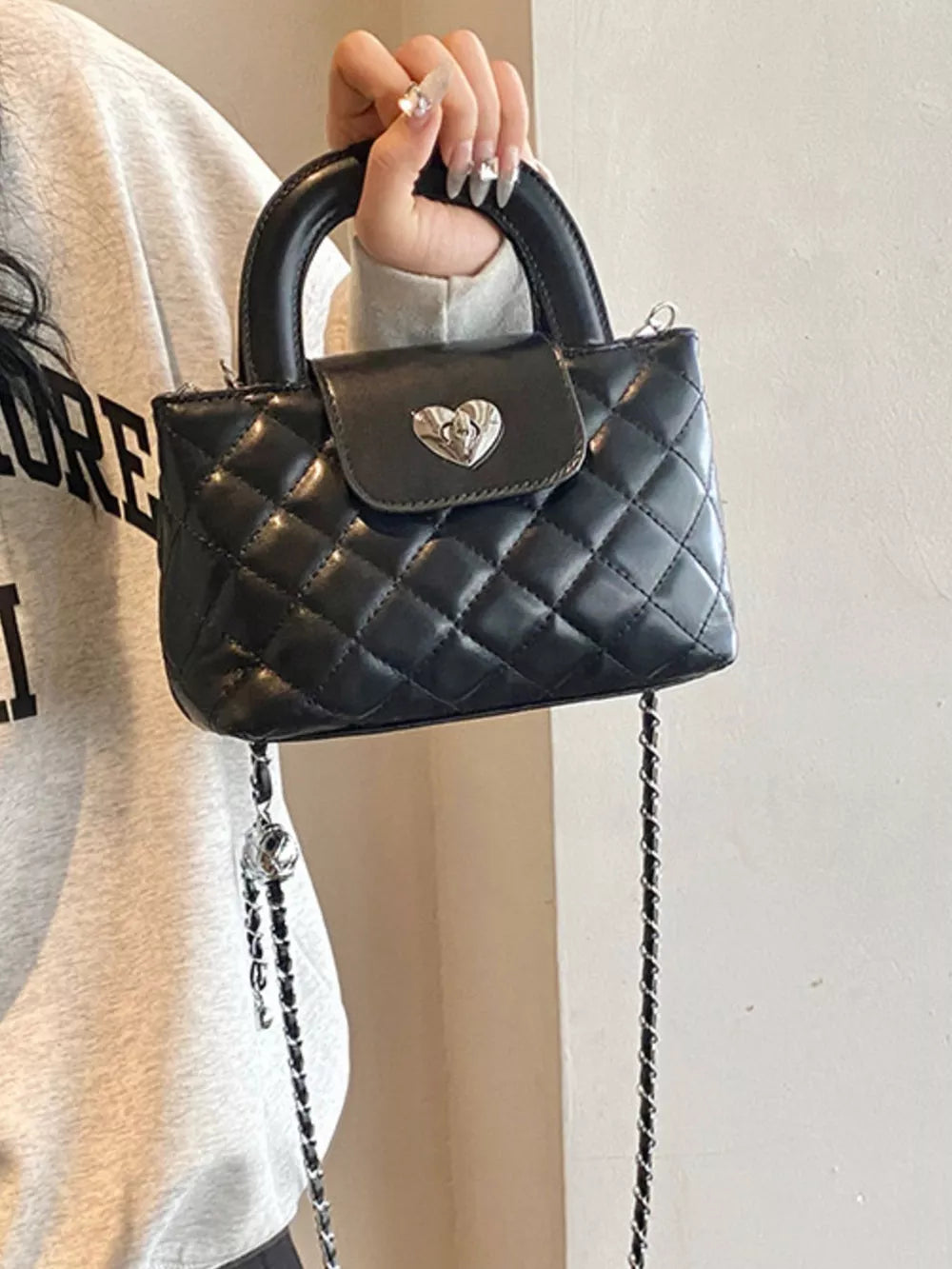 Quilted Heart Lock Crossbody Bag in Black, model styling view