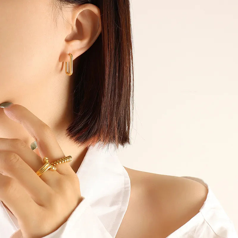 Gold Wide Triangle geometric steel huggie earrings on model