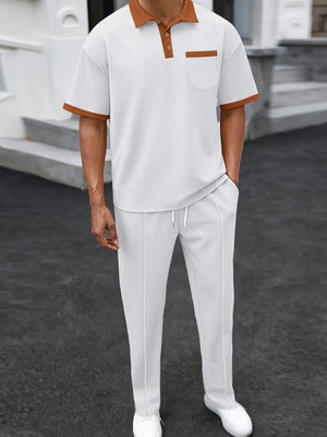 White textured polo shirt with contrast collar and pocket, paired with matching track pants.