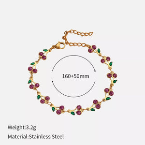 Gold-plated bracelet with pink cherry clusters and green leaves, adjustable length.