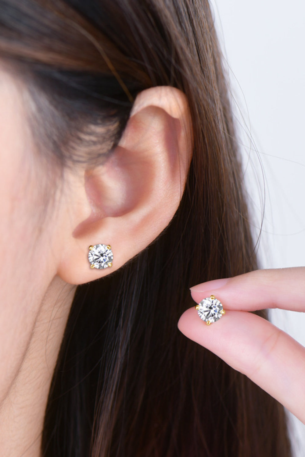 Gold moissanite solitaire stud earrings with brilliant cut stone.