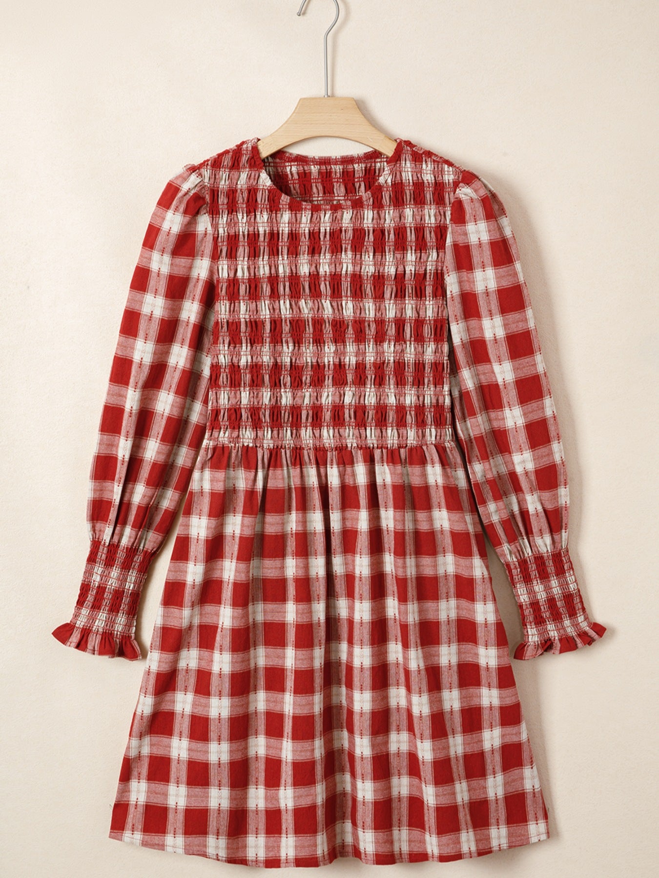 Red plaid cotton mini dress with smocked bodice, puff sleeves, and ruffled cuffs.