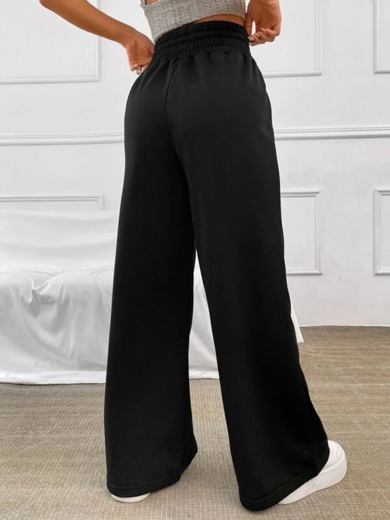 Black wide-leg sweatpants with a drawstring waist and elastic waistband.