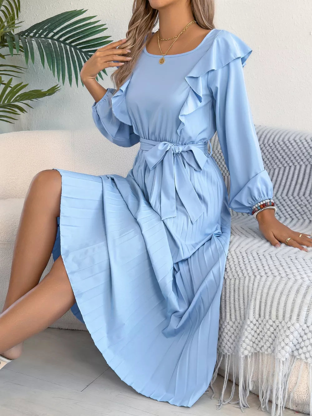 Blue A-line midi dress with ruffles, tie waist, and pleated skirt.