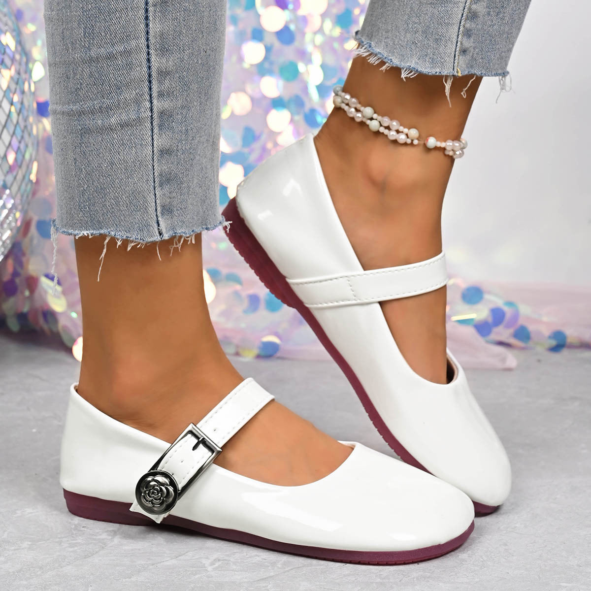 White patent buckle strap Mary Jane loafers with rose detail and pearl anklet.