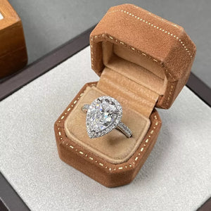 Elegant moissanite teardrop ring in sterling silver with halo setting