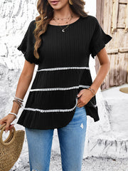 Black ribbed tiered ruffle trim blouse with white pom-pom trim detail.