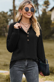 Textured black polo-neck sweater with button detail and long sleeves.