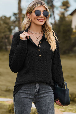 Textured black polo-neck sweater with button detail and long sleeves.