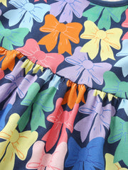 Toddler dress with allover colorful bow print and ruffled tier