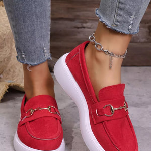Red slip-on loafers with gold horse-bit detail and white soles.
