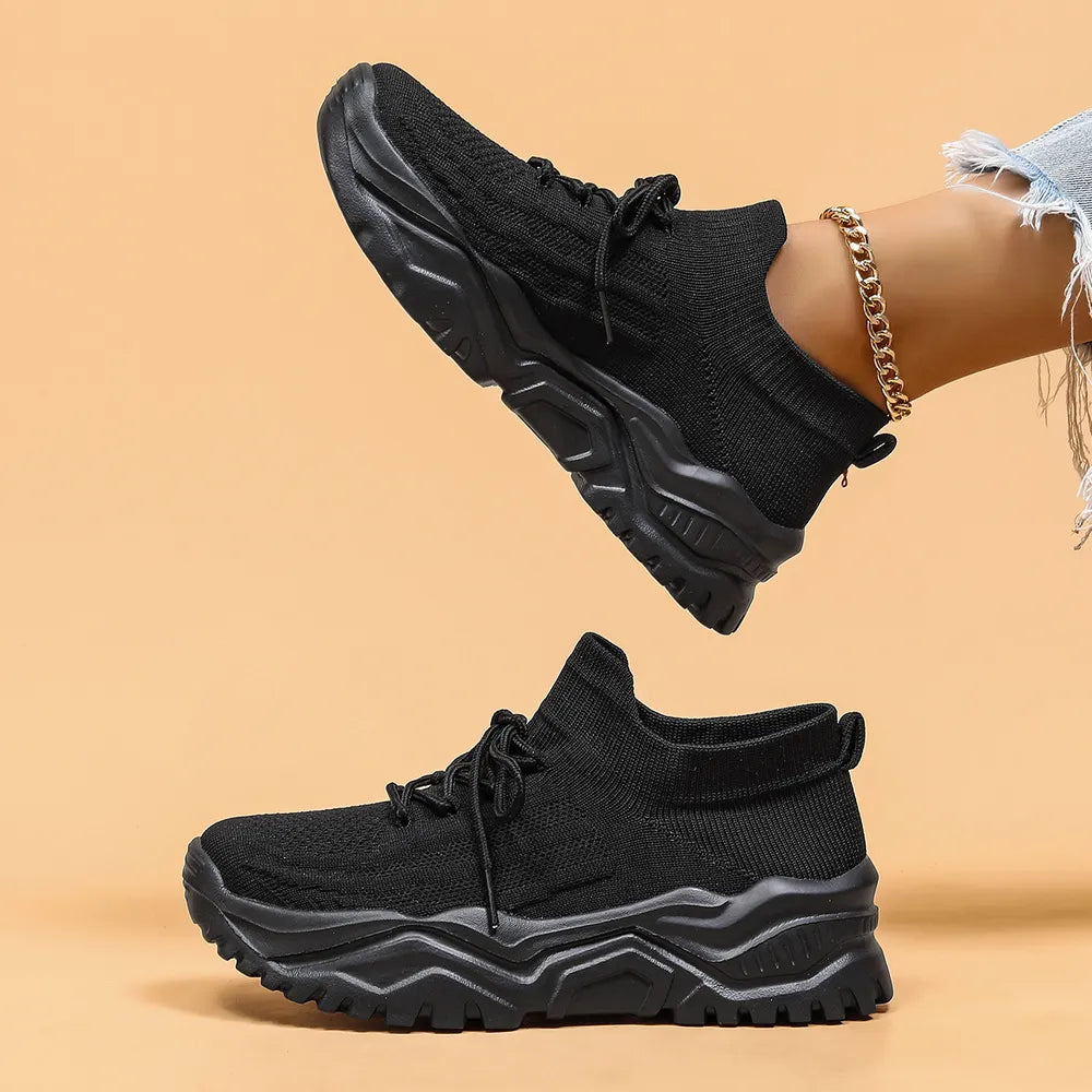 Black textured knit sneakers with lace-up closure and chunky sole.