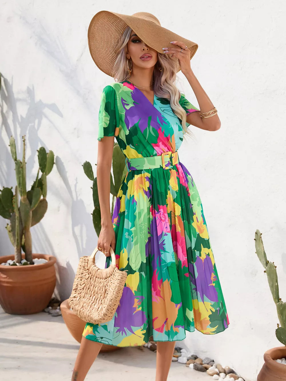 Tropical pleated midi dress with belt in vibrant floral print and green.