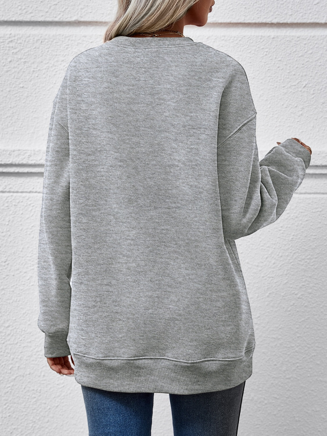 Gray crewneck sweatshirt with long sleeves and ribbed cuffs and hem.