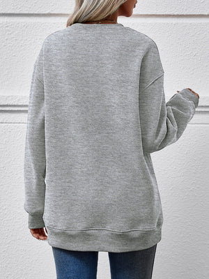 Gray crewneck sweatshirt with long sleeves and ribbed cuffs and hem.