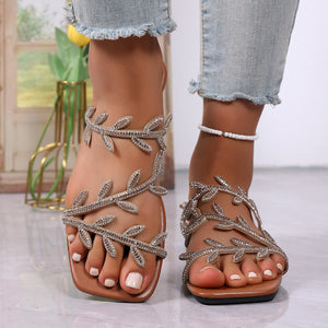 Brown flat sandals with rhinestone leaf embellishments and open toe