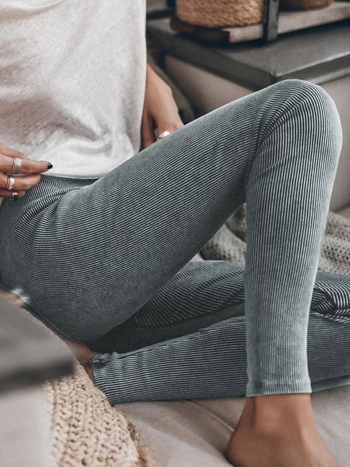Dark gray ribbed leggings with a subtle pinstripe pattern, styled casually.