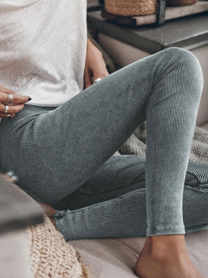 Dark gray ribbed leggings with a subtle pinstripe pattern, styled casually.
