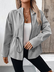 Gray hooded utility jacket with cinched waistline and black trim, worn open over a white tank top.