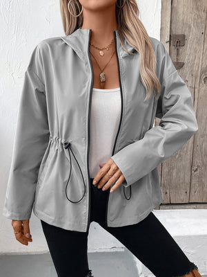 Gray hooded utility jacket with cinched waistline and black trim, worn open over a white tank top.