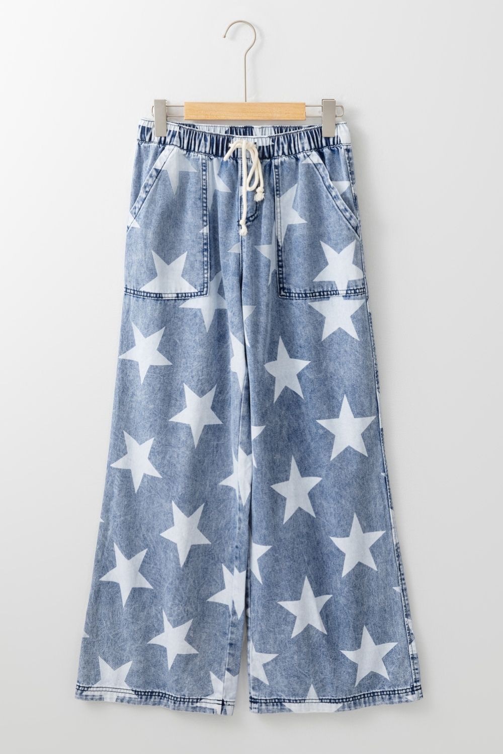 Cosmic Wash Star Print Palazzo Jeans in medium blue denim with white stars and a drawstring waist.