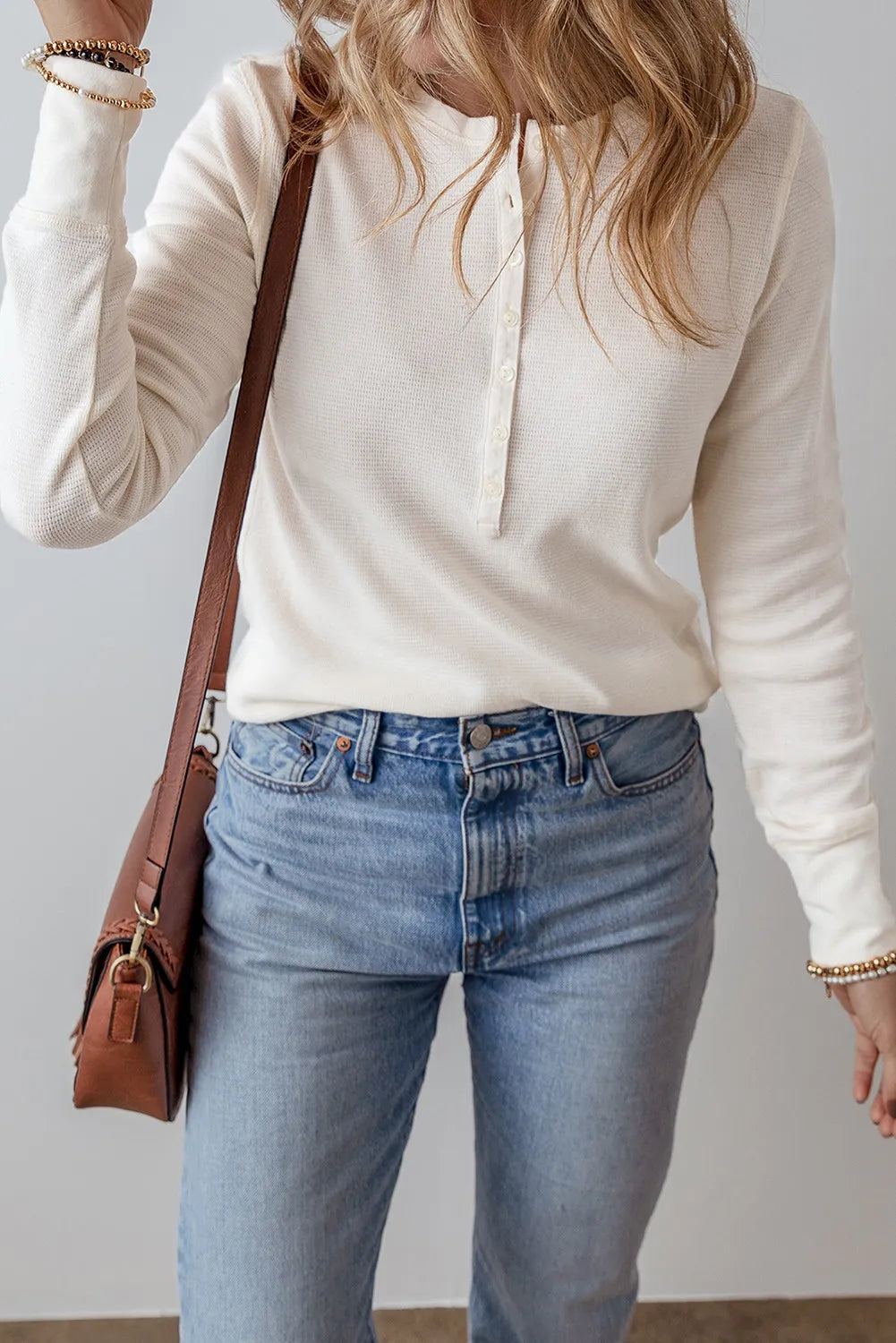 White waffle knit long sleeve henley blouse with button placket and crew neck.
