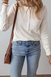 White waffle knit long sleeve henley blouse with button placket and crew neck.