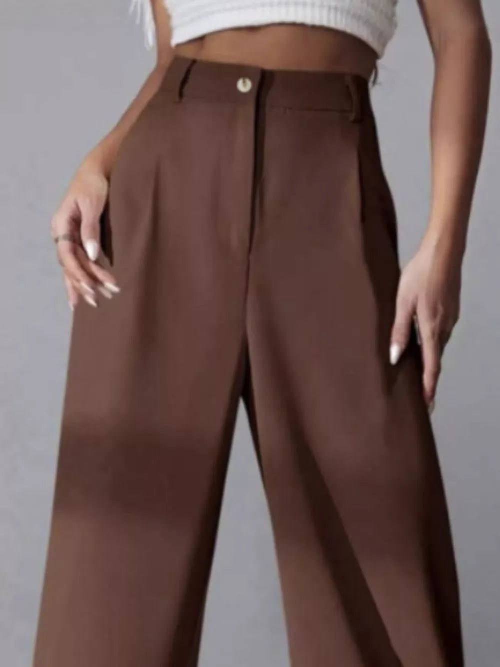 Brown high-waisted pleated wide-leg maternity trousers with button closure.