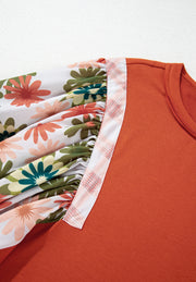 Orange-red blouse with floral patchwork balloon sleeves and plaid trim