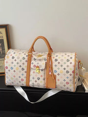 Vibrant monogram leather travel bag with tan trim and gold hardware, featuring a colorful all-over pattern.