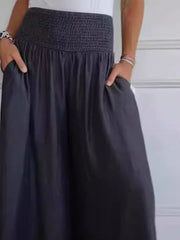 Smocked waistline flow trousers in black with pockets.