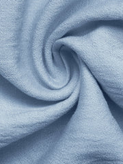 Blue maternity wrap romper fabric detail with soft texture and draped folds.