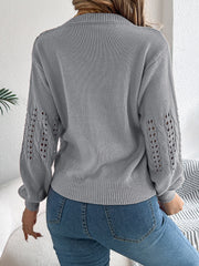 Gray knit sweater with openwork cable knit sleeves and crew neck.