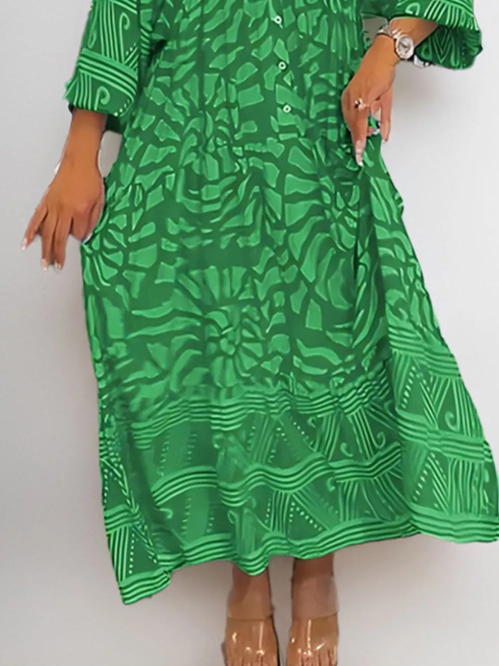 Green abstract print midi dress with 3/4 sleeves and pockets.